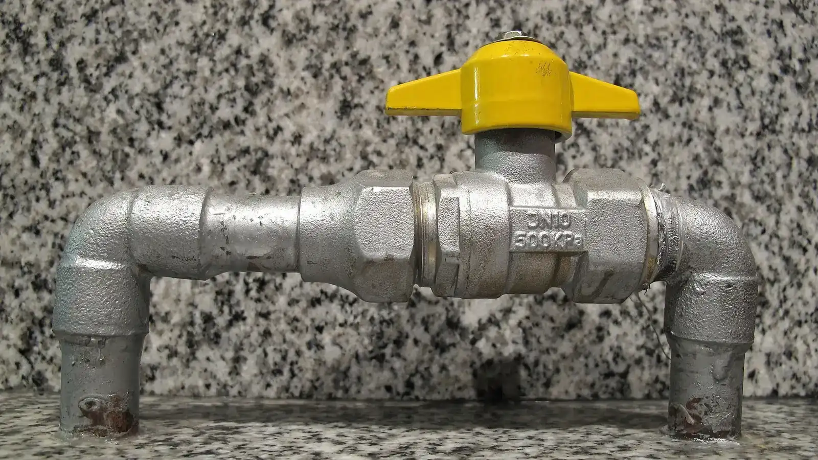 Row of blue pneumatic actuators mounted on automated butterfly valves at a plant