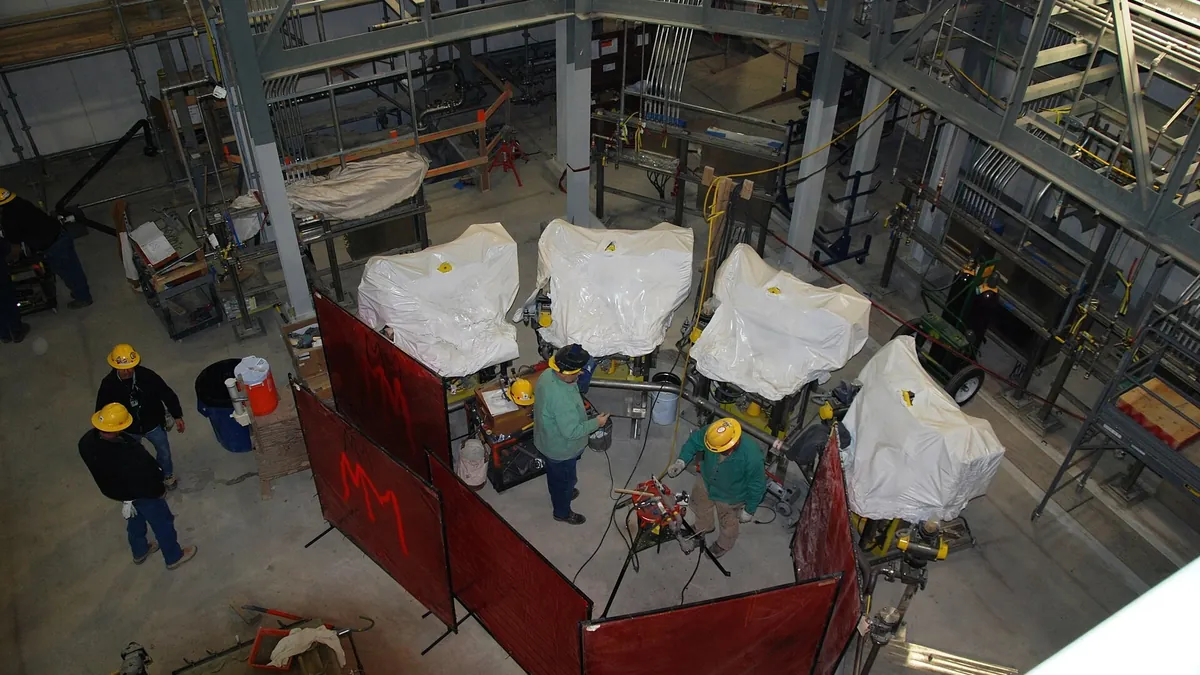 Field workers servicing valves and vessels at a plant site